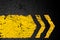 Grunge distressed yellow direction road marking on dark metal ba