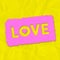 A grunge effect pink and yellow LOVE typographical graphic illustration with creased paper background