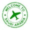 Grunge green welcome to Saudi Arabia word with airplane icon round rubber stamp on white background