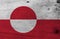 Grunge Greenland flag texture, white and red color with a counterchanged disk slightly off-centre towards the hoist.