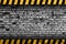 Grunge grey brick wall background with warning stripes