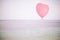 Grunge pink balloon over sea sky background with retro filter effect