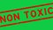 Grunge red non toxic word square rubber stamp zoon out from green background