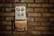 Grunge urban background of a brick wall with an old out of service payphone