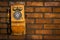 Grunge urban background of a brick wall with an old out of service payphone