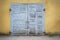 Grunge wooden plank door, dirty stucco wall background