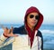 Grunge young man with hood at the beach