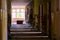 Grungy hallway in an abandoned building with light coming from the rooms to the right.