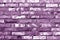 Grungy purple toned brick wall texture.