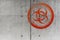 Grungy red biohazard warning symbol on rough concrete wall