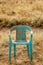 Grungy Retro Damaged Plastic Green Chair Abandoned in a Field