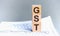 GST word written on wood block. Wooden block with words GST - acronim GST - Goods and Services Tax