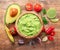 Guacamole, guacamole ingredients and chips on wooden background. Flat lay