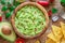 Guacamole, guacamole ingredients and chips on wooden background. Flat lay