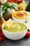 Guacamole and hummus in white bowls