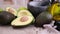 guacamole ingredients - Avocados whole and cut on concrete table with a marble mortar