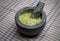 guacamole inside molcajete (traditional mexican mortar and pestle for grinding spices) avocado dip on striped tablecloth