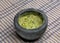 guacamole inside molcajete (traditional mexican mortar and pestle for grinding spices) avocado dip on striped tablecloth