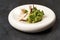 Guacamole with pita chips on white plate. Chef`s signature dish