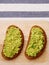 Guacamole sandwich on light background. avocado sandwiches on wooden board and textile top view