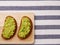 Guacamole sandwich on light background. avocado sandwiches on wooden board and textile top view