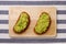 Guacamole sandwich on light background. avocado sandwiches on wooden board and textile top view