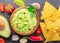 Guacamole sauce and guacamole ingredients, popular Mexican food, on slate serving board. Top view