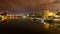 Guadalquivir river of Seville, night scene with lights in the city and reflections in the calm water, panoramic cityscape