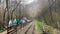 Guamka, Russia april 17, 2021: Rear view of tourists hiking on platform near railway in mountainous terrain. Group of