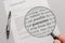 Guarantee conditions of a contract are checked carefully with a magnifying glass - english language