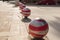 Guardamar del Segura, Alicante, Spain; December 8 2.017: Red and white bollards on stone sidewalk