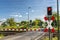 Guarded railroad crossing with closed barriers, red warning light and cross of Saint Andrew.