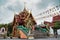 Guardian Nagas, Flags and Colorful decorated buildings mark the street entrance to Wat Nak Prok, The Naga Temple