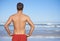 Guarding the coast. Cropped rear view of a male lifeguard looking out at the ocean.