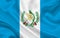 Guatemala country flag on wavy silk fabric background panorama
