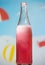 Guava fizzy bottle with foam isolated on blue background