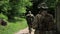 Guerilla warriors squad walking in line formation carrying their guns in urban environment.