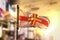 Guernsey Flag Against City Blurred Background At Sunrise Backlight