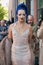 Guest with white transparent dress blue hair and golden necklaces before Fendi fashion show,