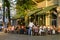 Guests eating and drinking in a restaurant in the center of Berlin. The fully occupied tables and chairs stand on the sidewalk in