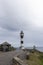 Guiding Light Amidst the Storm: A Striped Lighthouse Overlooking the Ocean