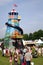 Guildford, England - May 28 2018: People walking towards a traditional old fashioned vintage Helter Skelter fairground slide on