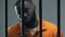 Guilty Afro-American criminal looking at camera through prison bars, judgment