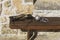 Guilty sign plate, metallic handcuffs and manacles on a wooden bench on a yellow limestone background