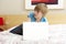 Guilty Teenage Boy Using Laptop In Bedroom