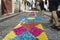 Guimaraes, Braga, Portugal. August 14, 2017: Narrow cobblestone alley with very colorful ornaments formed by small papers in its c