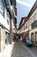 Guimaraes, Braga, Portugal. August 14, 2017: Narrow paved cobblestone alley, with tourists and a worker strolling. facades of Goth