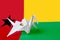 Guinea Bissau flag depicted on paper origami crane wing. Handmade arts concept