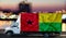 Guinea Bissau flag on the side of a white van against the backdrop of a blurred city and river. Logistics concept