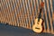 Guitar on beach fence with sunset illumination